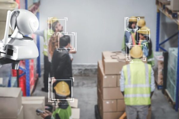 Surveillance camera monitoring warehouse workers with facial recognition in a Storage Unit.