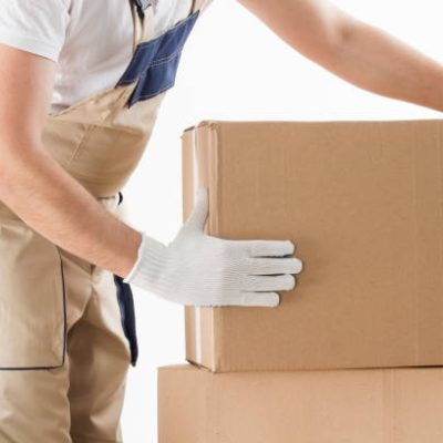 Relocation services concept. Mover in uniform with cardboardboxes isolated on white background.